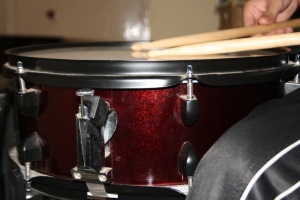 The snare drum should be placed between the legs